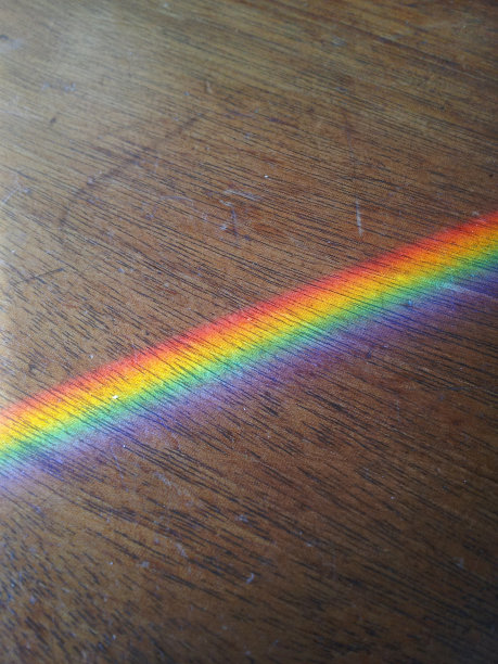 彩虹投射在坚硬的木质表面上图片下载