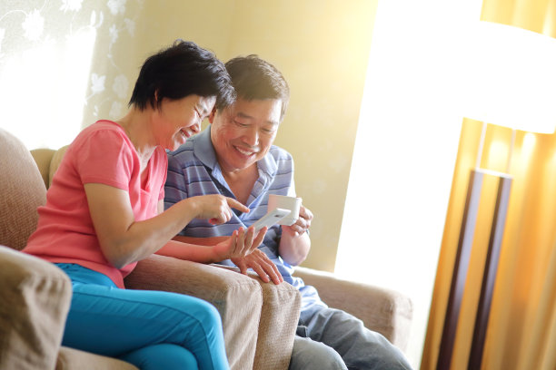 快乐的老年夫妇使用智能手机图片下载