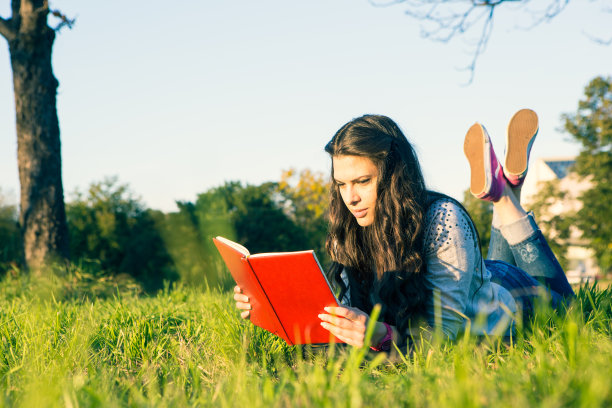 可爱的女孩在公园里看书图片下载