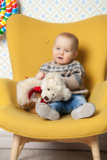 可爱的红头发小男孩在玩泰迪熊图片下载