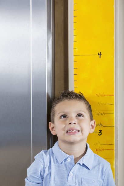 小男孩在生长表上测量他的身高图片下载