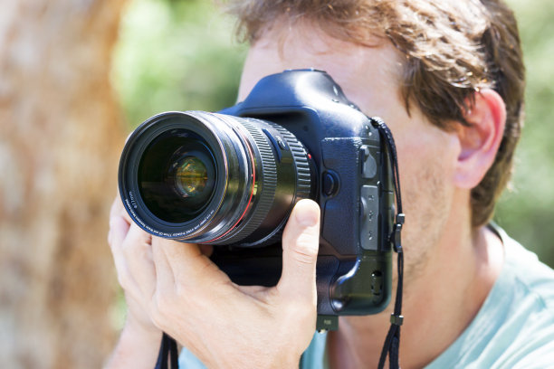 近距离男性摄影师手持单反相机图片下载