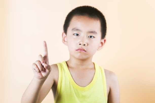 亚洲男孩站在橙色背景前图片下载