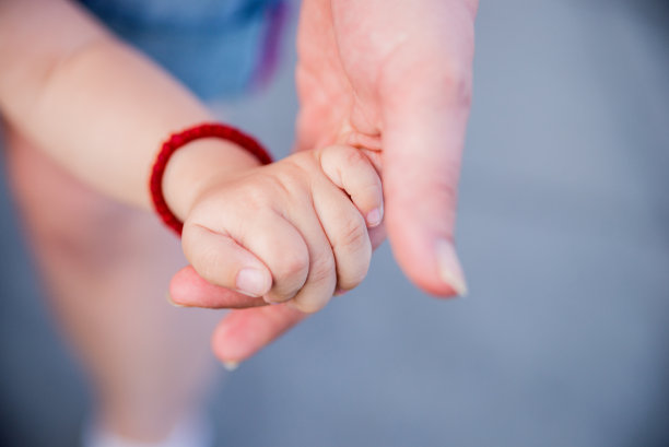 婴儿伸手抓住妈妈的照片图片下载