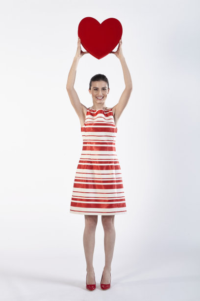 穿着礼服的女人拿着一个心形的礼盒图片下载