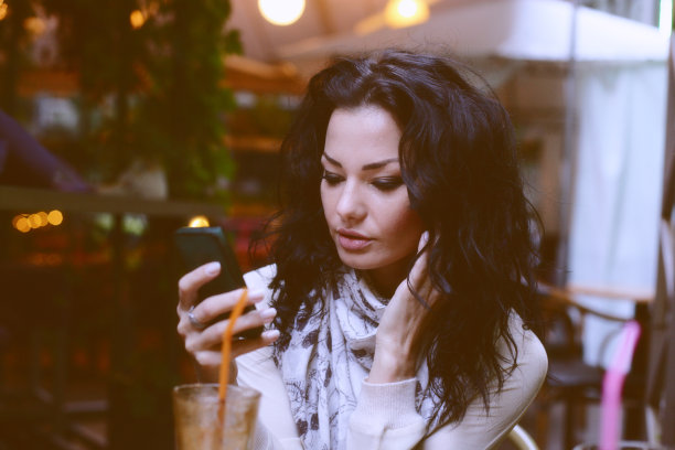 一位忧心忡忡的年轻女子在手机上发短信图片下载
