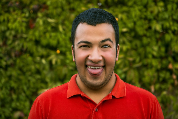 一个笑着伸出舌头的年轻人的肖像图片下载