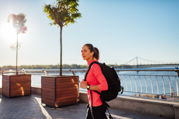 背着背包在户外行走的年轻女子素材图片