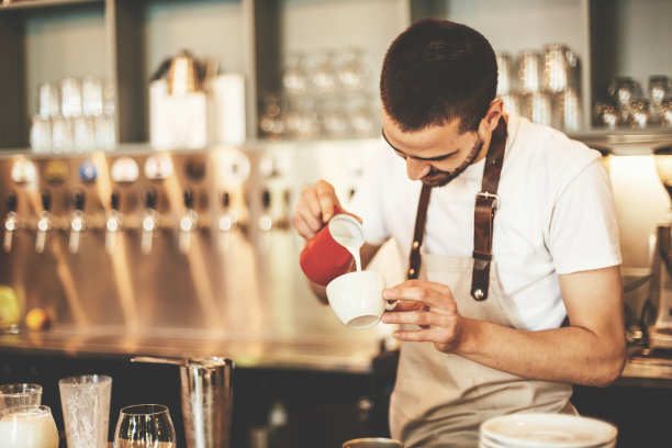 咖啡师把牛奶倒进咖啡图片下载
