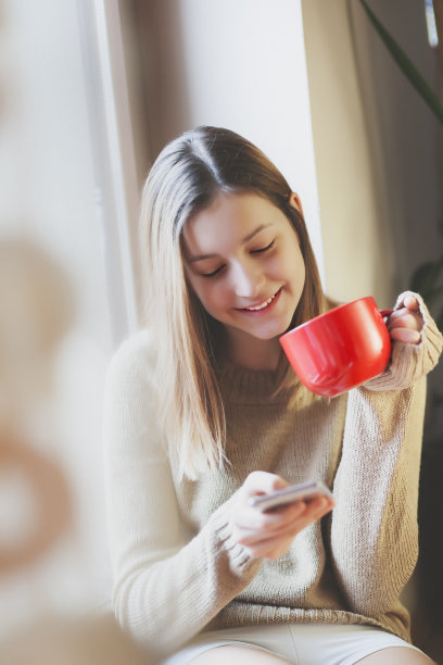 年轻女人早上喝咖啡，打电话图片下载