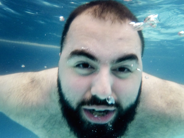 一个年轻人正在游泳池里休息图片下载