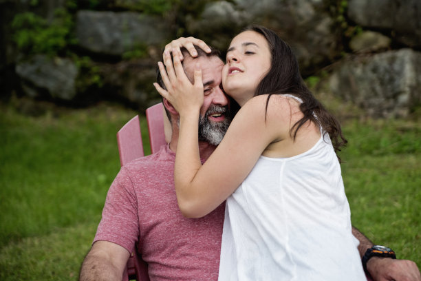 十几岁的女儿在夏天的户外表现出对胡子父亲的喜爱。图片下载