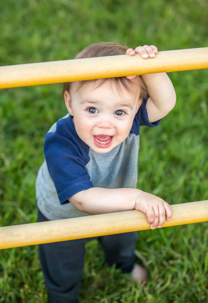 小男孩在外面玩黄色的操场梯子图片下载