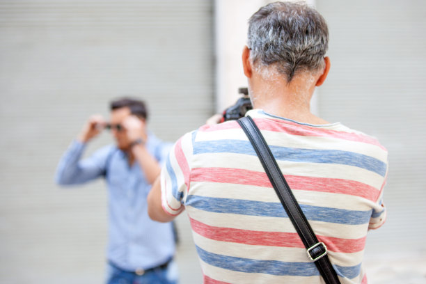 年轻的成年男子对摄影师摆姿势拍照图片下载