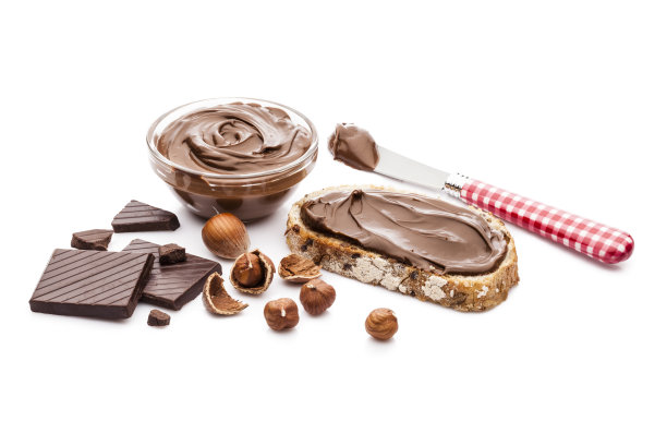 巧克力和榛子散布在面包片上，孤立在白色的背景上图片下载