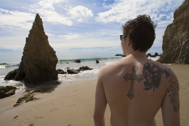 一个有纹身的年轻人望着大海图片下载
