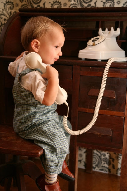 蹒跚学步的孩子使用古董手机图片下载