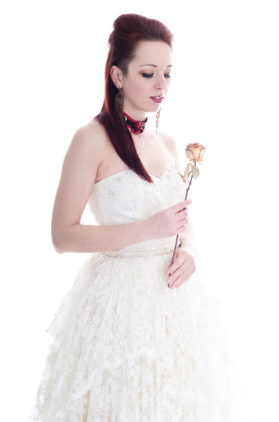 红发新娘捧着干玫瑰。图片下载