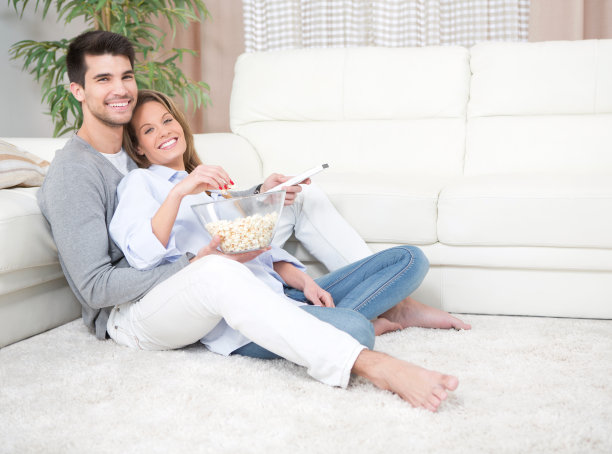 一对夫妇在家里看电视。图片下载