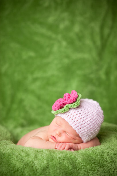 新生女婴戴着针织帽安静地睡觉图片下载