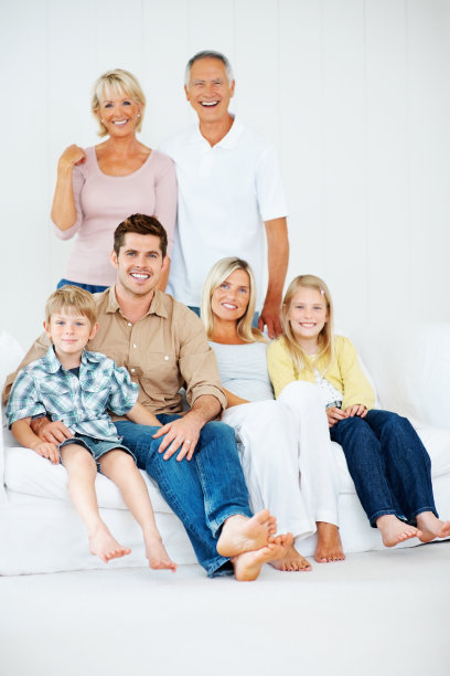 几代同堂的一家人坐在沙发上微笑图片下载
