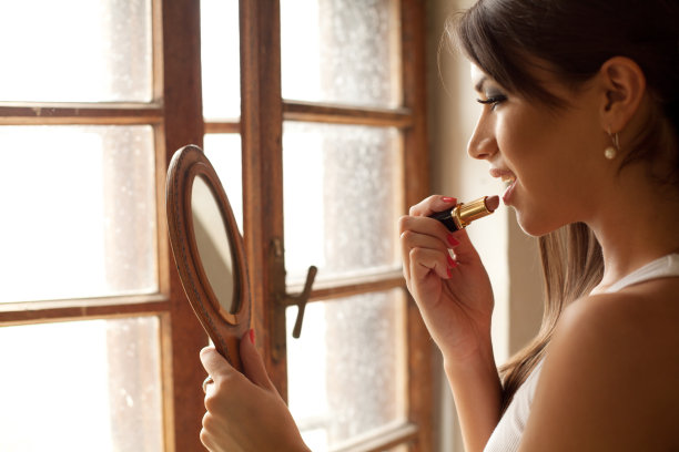 漂亮的女孩正在涂口红图片下载