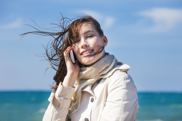 年轻女子在海边使用手机图片下载