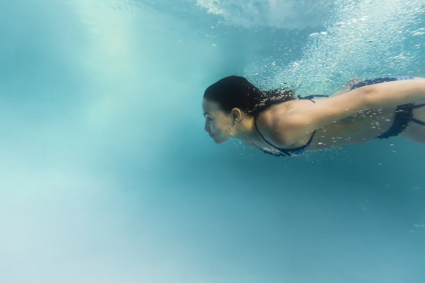 8岁女孩潜水在水下的侧面图片下载