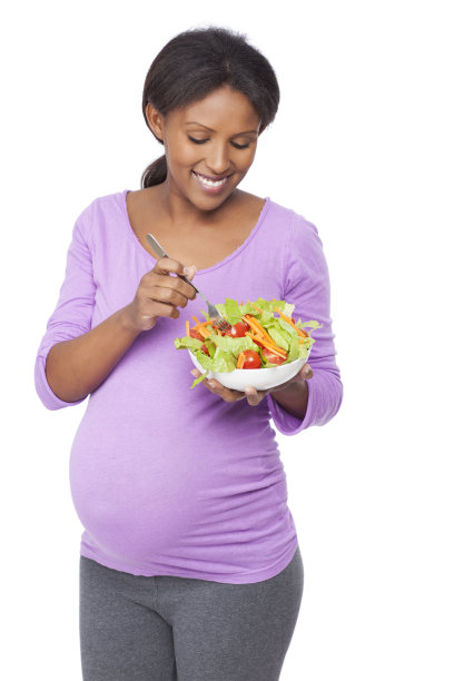 微笑的孕妇在吃新鲜的沙拉。图片下载