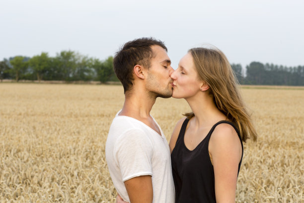 夏天的肖像亲吻年轻的成年夫妇，背光图片下载