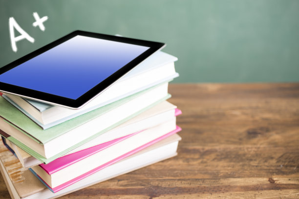 回到学校。教育。课本，桌上放着平板电脑。黑板。图片下载