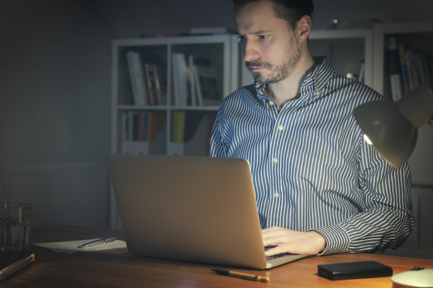 一个商人在家里用笔记本电脑工作到很晚图片下载