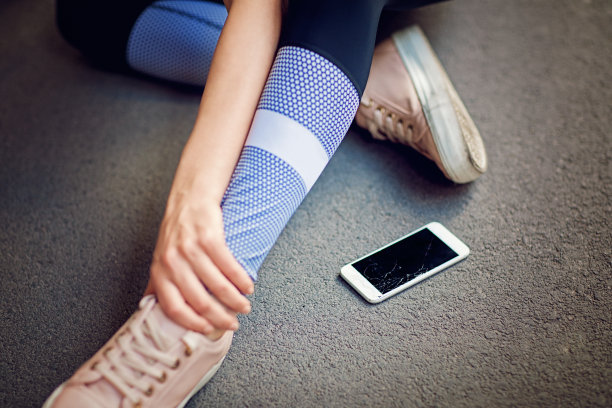 受伤的跑步者坐在地上，手机坏了图片下载