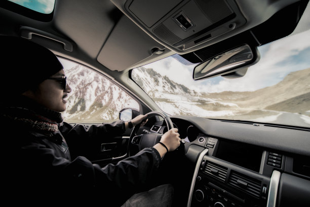 一个手放在方向盘上开车的男人图片下载