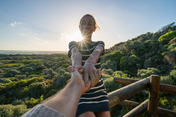 日落——年轻女子邀请男子加入她图片下载