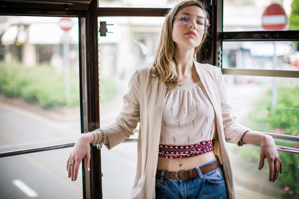 在电车上摆姿势的漂亮年轻女子图片下载