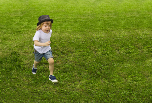 可爱的男孩在草地上奔跑图片下载