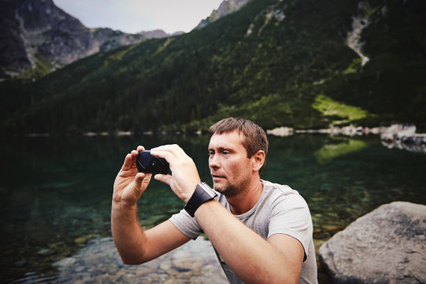 一名成年男子，在太特拉喀尔巴阡山脉的摩尔斯基奥科湖用智能手机拍照，图片下载