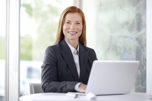 在笔记本电脑上工作的成熟商业女性图片下载