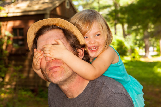 父亲和女儿在后院玩。图片下载