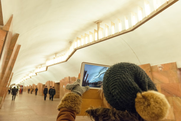 俄罗斯，一名女子用平板电脑拍摄莫斯科地铁站图片下载