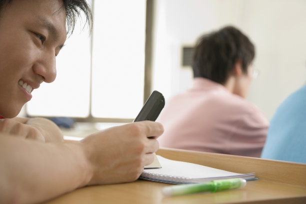 男大学生在课堂上使用手机图片下载