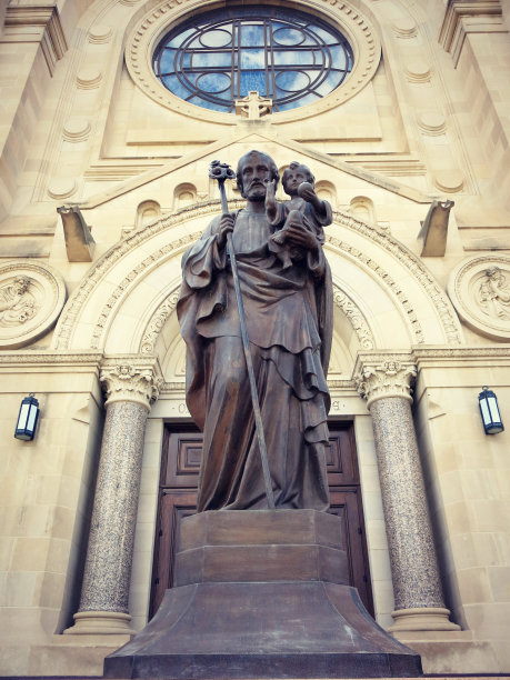 在教堂前抱着小耶稣的约瑟夫的低角度照片图片下载