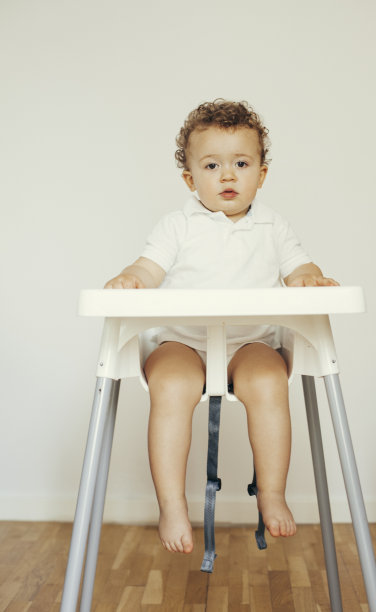 蹒跚学步的孩子坐在高椅子上图片下载