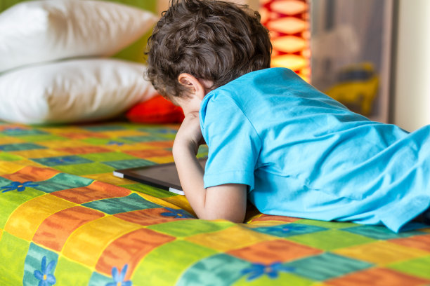 小男孩在平板电脑上看动画片图片下载