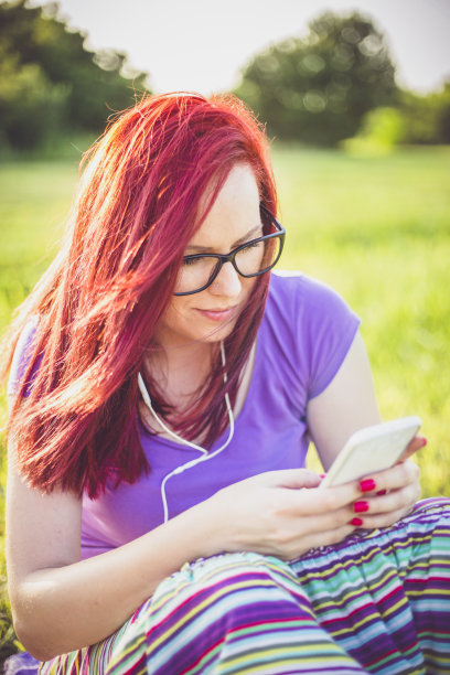 一个年轻女子在阳光明媚的日子里听音乐图片下载