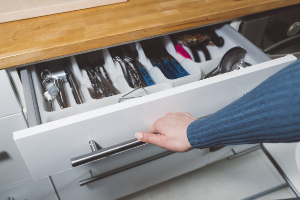打开白色厨房抽屉的手的特写图片下载