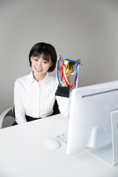 成功的商业女性在办公室展示她的奖杯图片下载