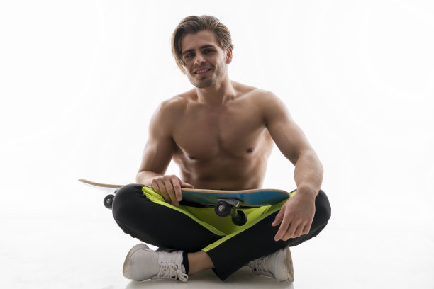 肌肉英俊的男人坐在滑板上图片下载