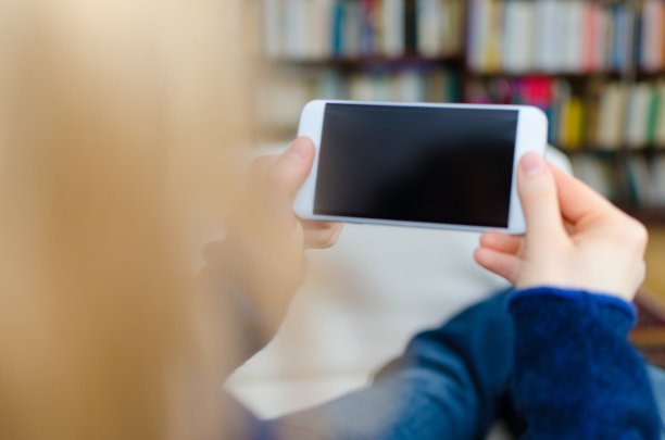 金发女人拿着现代智能手机有空白屏幕和拷贝空间素材图片